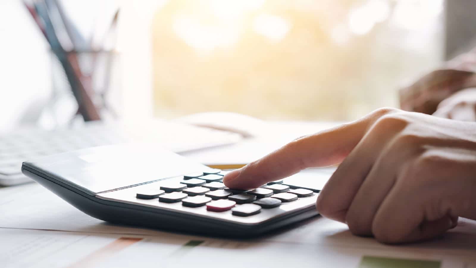 Hand On Calculator Stock Photo