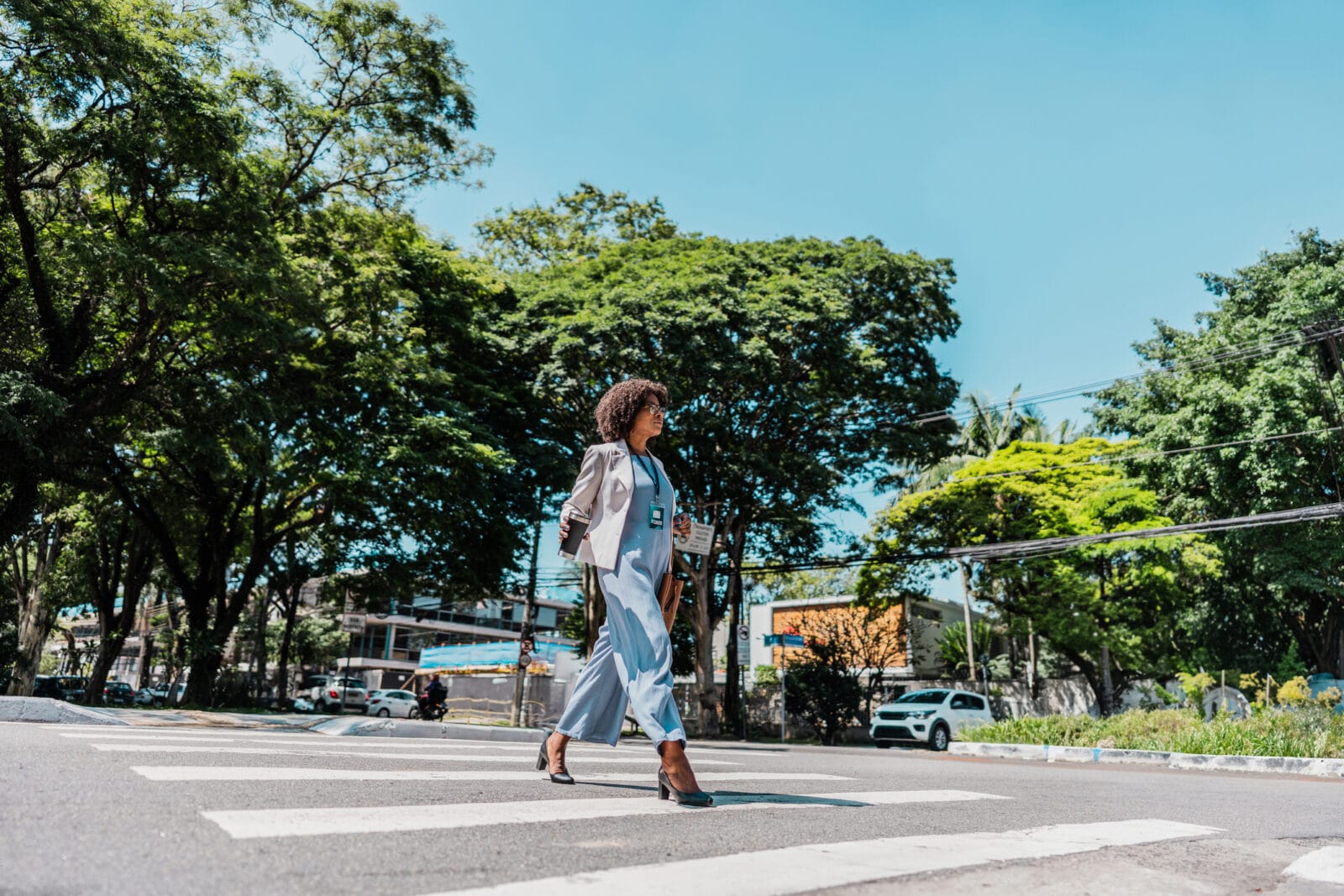 A woman crosses the street at a crosswalk.